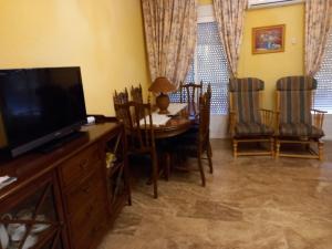 a dining room with a television and a table and chairs at Alojamiento Vacacional Inma in Cazorla