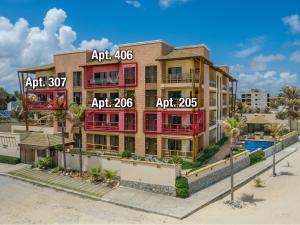 um edifício de apartamentos com janelas vermelhas e uma piscina em Beach front Varandas Do Mar em Cumbuco