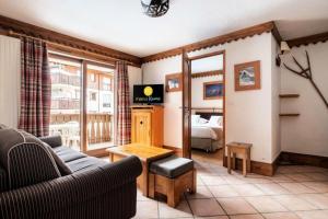 een woonkamer met een bank en een bed bij Résidence La Ginabelle - maeva Home - Appartement 3 Pièces 6 Personnes - P 304 in Chamonix-Mont-Blanc