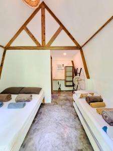 two beds in a room with white walls at Triangle Palms Siargao in General Luna