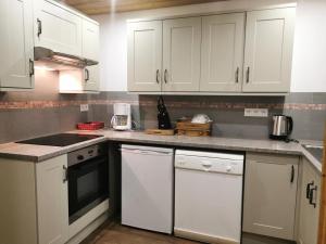 a kitchen with white cabinets and a counter top at Résidence Terrasse - La Terrasse 11 - Joli appartement, skis aux pieds MAE-5054 in Valmorel