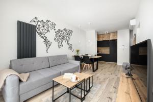 uma sala de estar com um sofá e uma mesa em Unique Baltic Marina Residence with Sauna & Fitness by Renters em Colberga