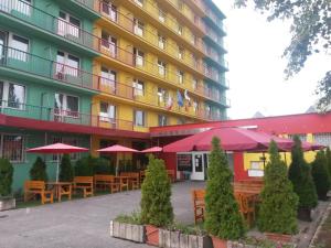 a hotel with tables and umbrellas in front of it at ABC Hotel Nitra in Nitra
