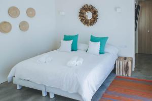 Schlafzimmer mit einem weißen Bett und einem Spiegel an der Wand in der Unterkunft Can Albano - Santa Eulalia in Santa Eulària des Riu