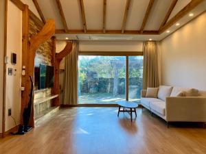 a living room with a couch and a table at Bijarim Healing Pension in Jeju