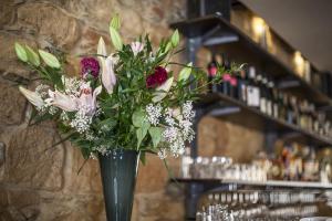 eine Vase voller Blumen auf einem Tisch in der Unterkunft Rozmaryn Hotel B&B in Rakovník