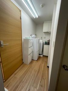 a room with a kitchen with a refrigerator and a door at ACT Residence No.1 in Tokyo