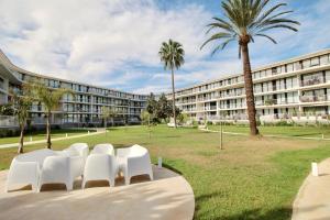 a group of white chairs in front of a building at Denia Beach 40 in Denia