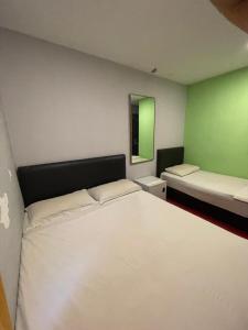 a bedroom with a large white bed and a mirror at Hotel Rim Global Subang in Subang Jaya