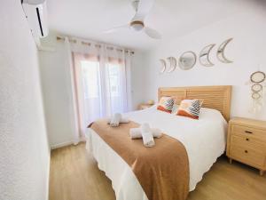 ベニカシムにあるCasa Ibicenca en Benicasim a 3 minutos de la playaのタオルが敷かれた大きなベッドのある寝室