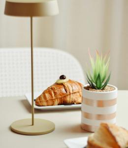 a table with a plate of bread and a plant at B&B Dei Vicari in Frattamaggiore