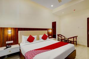 1 dormitorio con 1 cama grande con almohadas rojas en OYO SAI GRAND LUXURY ROOMS, en Tirupati