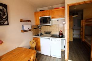 eine kleine Küche mit einer Spüle und einer Mikrowelle in der Unterkunft Résidence Le Centre - 2 Pièces pour 4 Personnes 193343 in Champagny-en-Vanoise