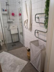 a white tiled bathroom with a shower and a sink at Eurovision 2024 in Malmö