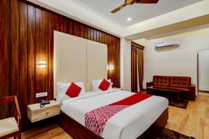 a hotel room with a bed and a chair at OYO SAI GRAND LUXURY ROOMS in Tirupati