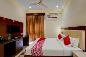 a hotel room with a bed and a flat screen tv at OYO SAI GRAND LUXURY ROOMS in Tirupati
