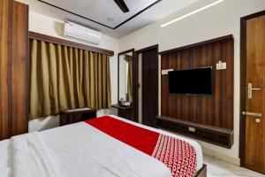 sypialnia z łóżkiem i telewizorem z płaskim ekranem w obiekcie OYO Hotel Golden Residency w mieście Bengaluru
