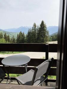 a table and chairs on a balcony with a view at Résidence Gollet - Studio pour 4 Personnes 884 in Valmorel
