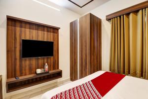 sypialnia z łóżkiem i telewizorem z płaskim ekranem w obiekcie OYO Hotel Golden Residency w mieście Bengaluru