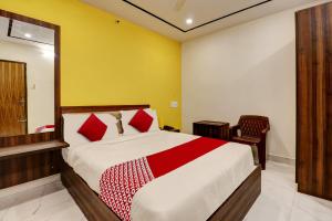 a bedroom with a large bed and a chair at OYO Hotel Golden Residency in Bangalore