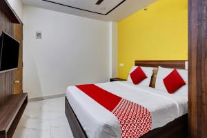 sypialnia z dużym łóżkiem z czerwonymi poduszkami w obiekcie OYO Hotel Golden Residency w mieście Bengaluru