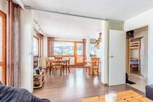 a living room and dining room with a table and chairs at LA MEIJE - Appartement MEIJE 55 pour 6 Personnes 204 in La Plagne Tarentaise