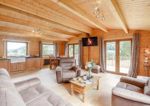 a living room with couches and a table at Riverview Lodge in Llanddulas