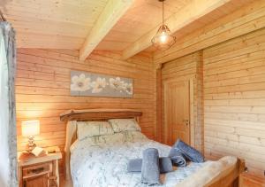 a bedroom with a bed in a wooden cabin at Riverview Lodge in Llanddulas