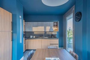 ミラノにあるUnico Studiosの青い壁のキッチン(木製テーブル付)