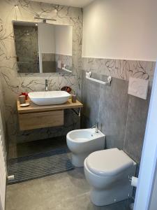 een badkamer met een wit toilet en een wastafel bij Royal House in Catania