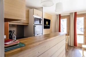 Mâcot La PlagneにあるRésidence Plagne Lauze - maeva Home - Appartement 2 pièces 5 personnes - S 984のキッチン(木製カウンタートップ、冷蔵庫付)