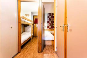 um quarto com 2 beliches e um corredor em Résidence Les Brigues - maeva Home - Appartement 2 Pièces 6 Personnes - Co 014 em Courchevel