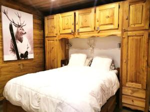 a bedroom with a white bed and wooden cabinets at Résidence Terrasse - La Terrasse 36 - Magnifique appartement cocooning, vue splendide MAE-4914 in Valmorel
