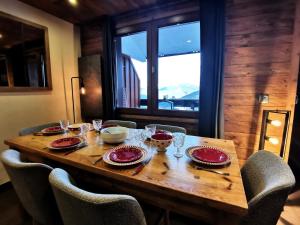 a wooden table with chairs and plates and glasses on it at Résidence Terrasse - La Terrasse 36 - Magnifique appartement cocooning, vue splendide MAE-4914 in Valmorel