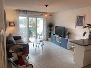 - un salon avec un canapé et une télévision dans l'établissement Appartement, 1 chambre, Piscine, Wifi..., à La Seyne-sur-Mer