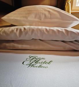 a bed with two pillows on top of it at Green Hostel Wrocław przy ZOO in Wrocław