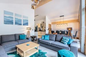 ein Wohnzimmer mit Sofas und einem Tisch in der Unterkunft Résidence LES TERRASSES DE LA VANOISE - Appartement LES TERRASSES DE LA VAN 414 in Champagny-en-Vanoise