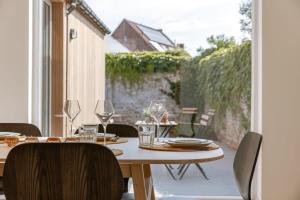 una mesa de madera con platos y vasos en el patio en Beautiful vacation home 'Valkehuisje' in Poperinge, en Poperinge