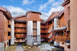 a row of apartment buildings with mountains in the background at Quartier La Forêt - maeva Home - Appartement 2 pièces 5 personnes - Sélection MAE-7134 in Valmorel