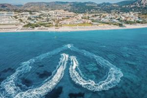 an aerial view of a beach with a boat in the water at Lindos Imperial Resort & Spa in Kiotari