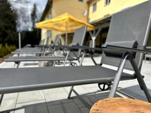 a row of black picnic tables with yellow umbrellas at Maiers Hotel in Bayerisch Eisenstein