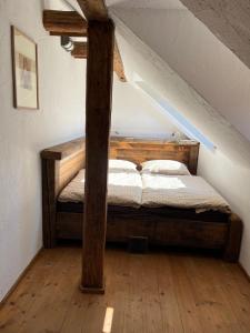 a bedroom with a wooden bed in a attic at folk cottage Vysna Boca in Vyšná Boca