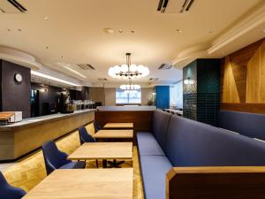 a restaurant with wooden tables and a bar at APA Hotel STAY Toyama in Toyama