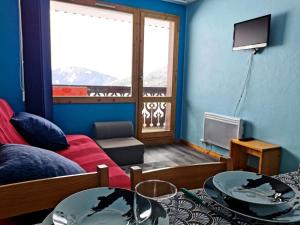 sala de estar con sofá rojo y ventana en Résidence Camarine - 2 Pièces pour 4 Personnes 964 en Valmorel