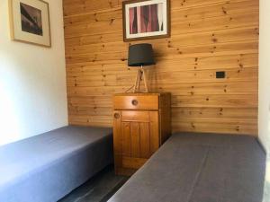 a room with two beds and a lamp in it at Résidence Prariond - 2 Pièces pour 5 Personnes 414 in Valmorel