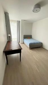 a bedroom with a bed and a desk and a table at Hugo apartment & parking in Rīga