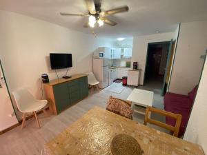 a living room with a ceiling fan and a kitchen at Bel appartement climatisé en rez de jardin, plage à 200 m, idéal vacances in Saint-Elme