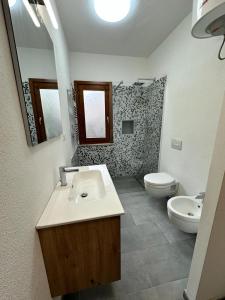 a bathroom with a sink and a toilet at La villetta TRE PALME in Valledoria