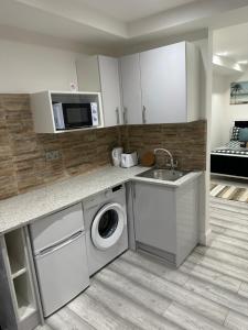 a kitchen with a washing machine and a sink at Guest&rest Ealing 5 in Ealing