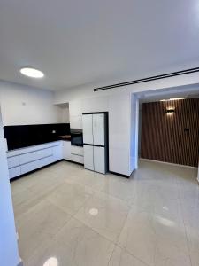 a large kitchen with white cabinets and a tile floor at בית בים in Netanya